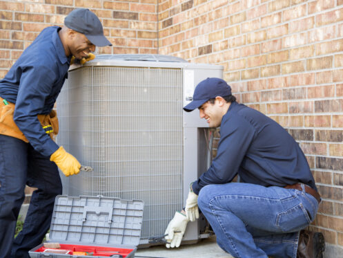 HVAC technicians replacing ac